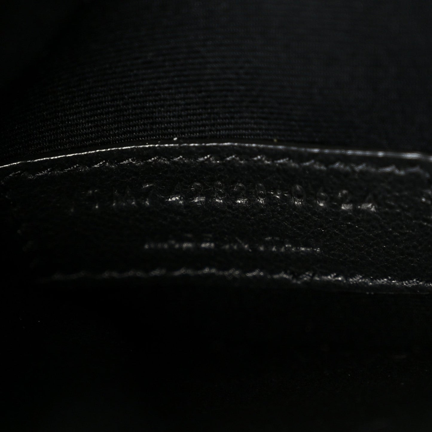 Saint Laurent shiny calfskin bucket bag, close-up of stitched leather trim