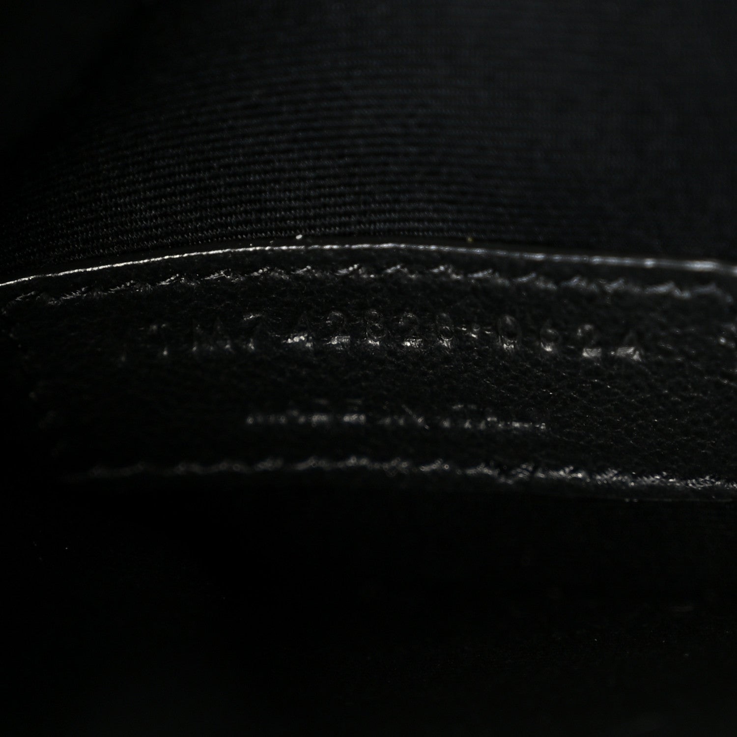 Saint Laurent shiny calfskin bucket bag, close-up of stitched leather trim
