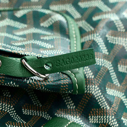 Reversible tote strap with green leather handle and metal D-ring over patterned fabric