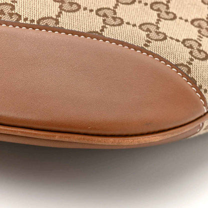Large shoulder bag curved leather trim with visible stitching over monogram canvas
