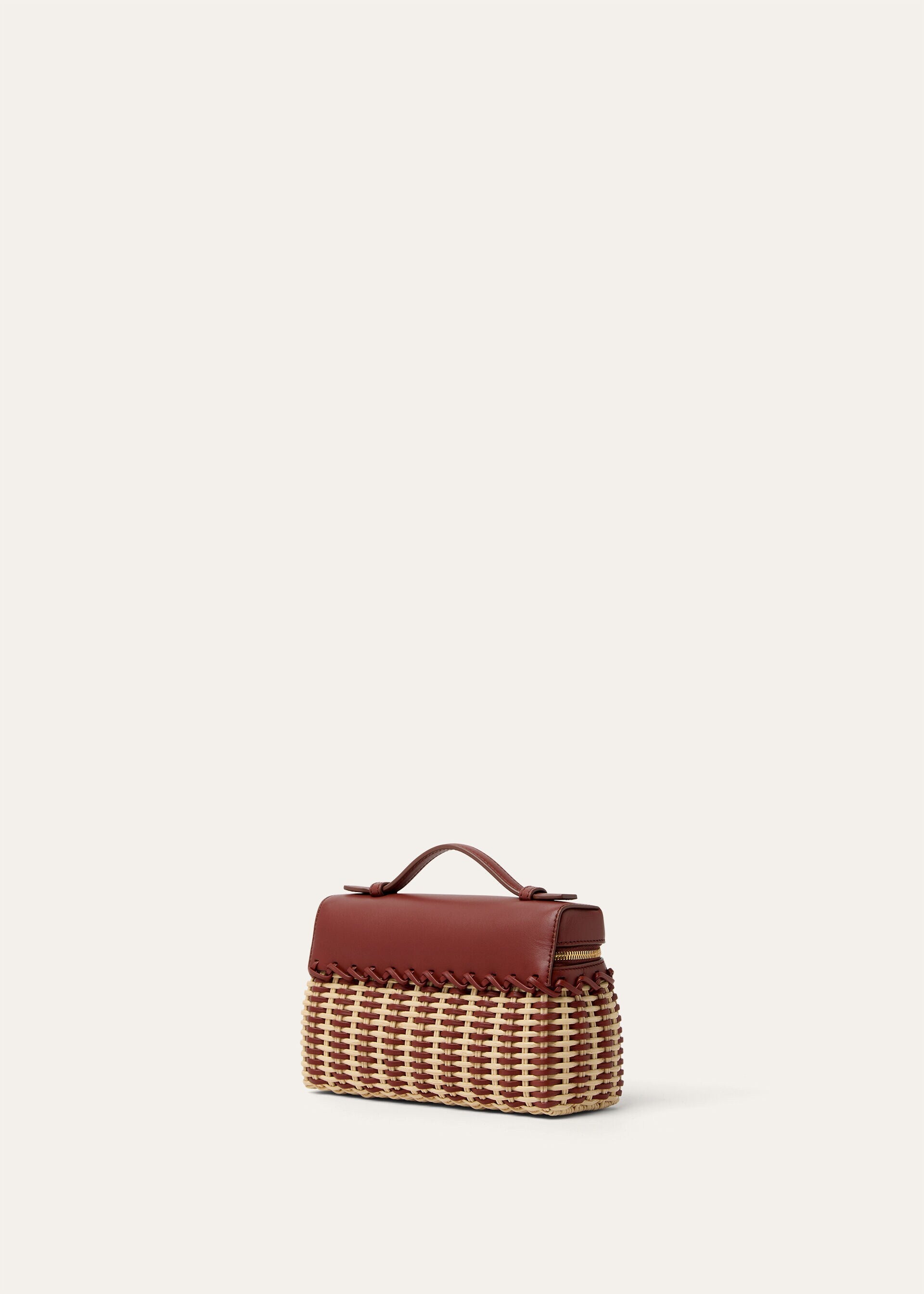 Wicker and calfskin mini pouch with top handle, side view showing woven body and zipper.