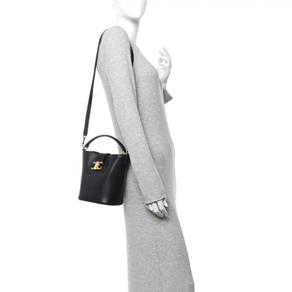 Small black Celine bag on shoulder strap, gold logo detail, smooth leather finish