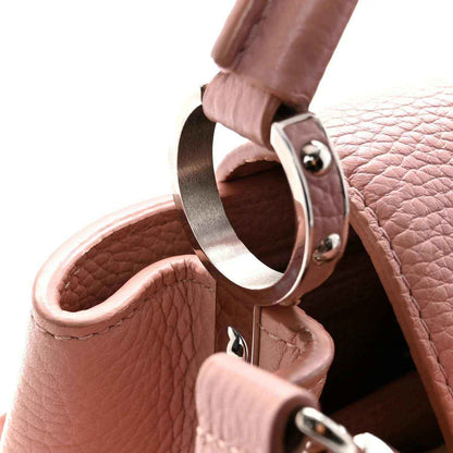 Pink leather handbag with metal strap ring and open interior lining