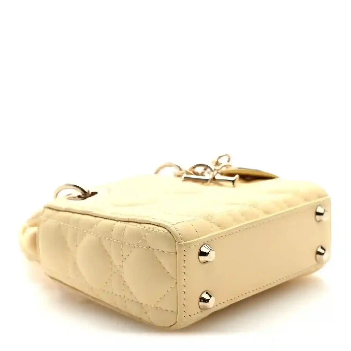 Micro Lady Dior handbag in soft yellow with top handle, metal studs, and structured sides