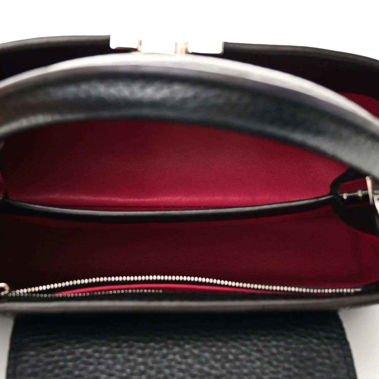 Black leather handbag interior with fuchsia lining and zip closure