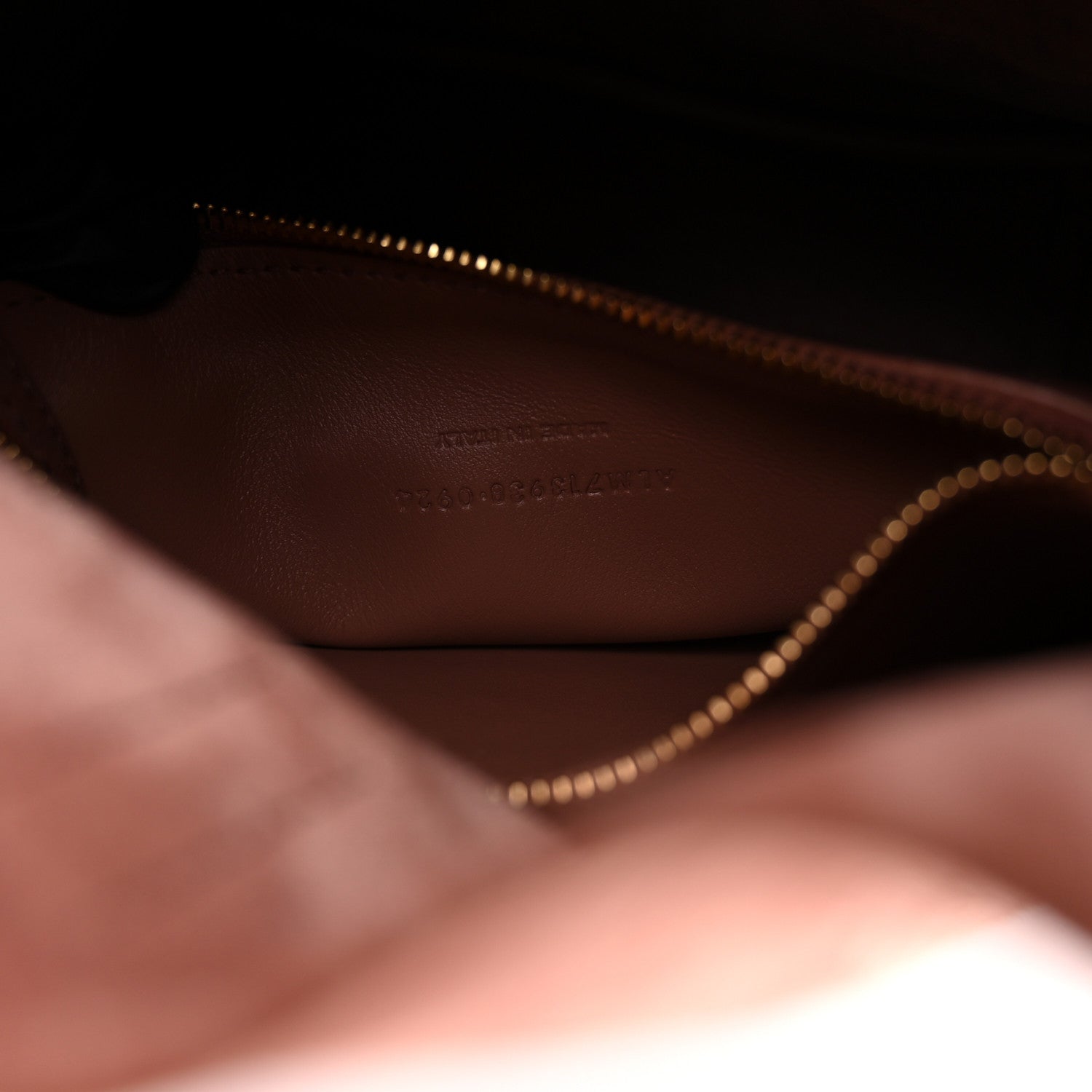 Small suede hobo bag interior close-up with gold-tone zipper teeth