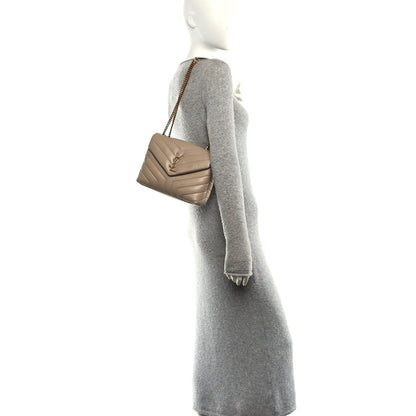 Dark beige quilted mini satchel with gold chain strap, worn on shoulder
