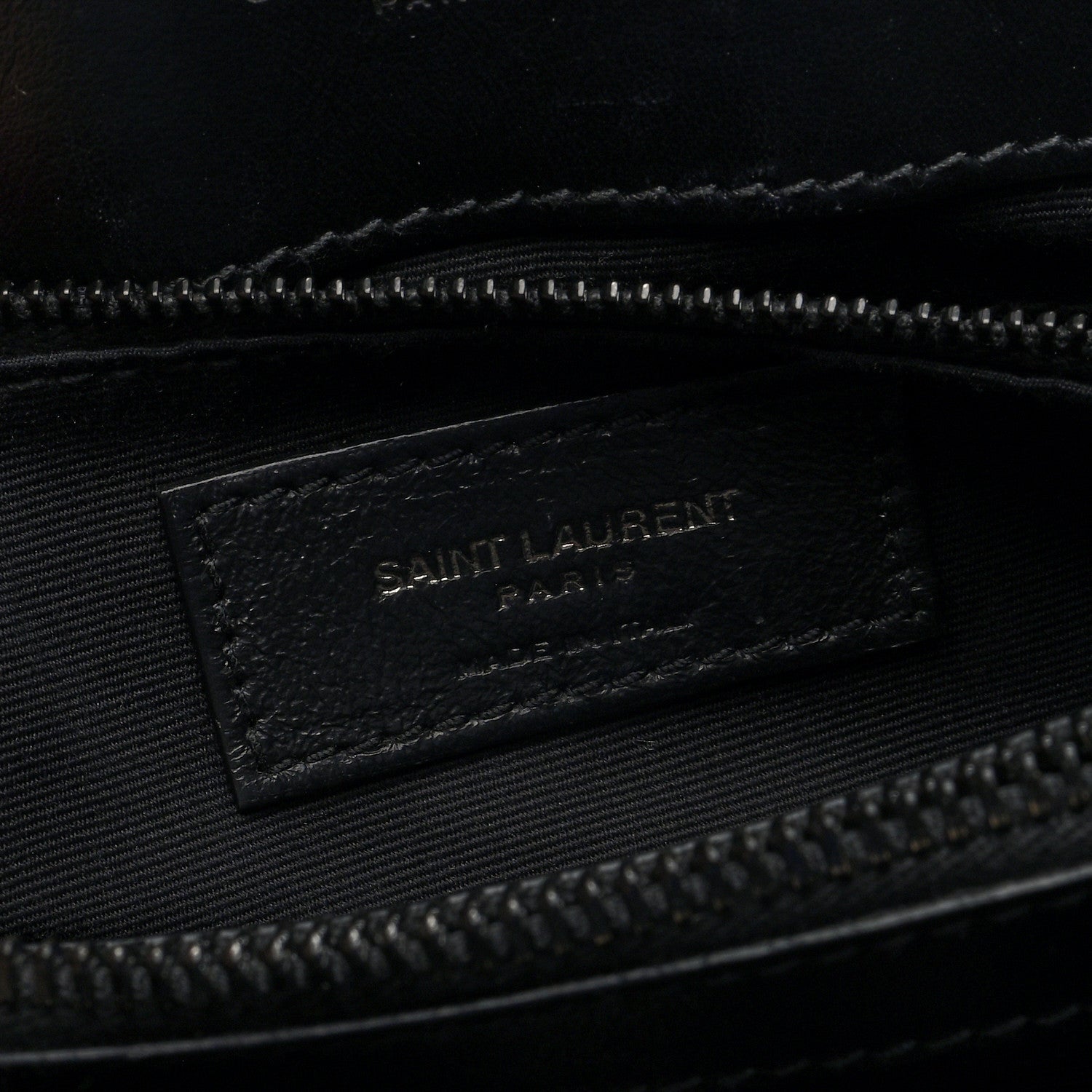 Black fabric interior tag with “SAINT LAURENT” logo inside satchel
