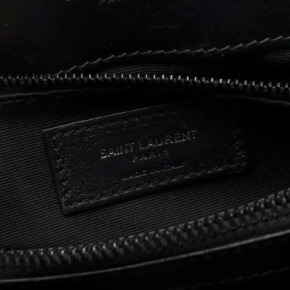 Black fabric interior tag with “SAINT LAURENT” logo inside satchel