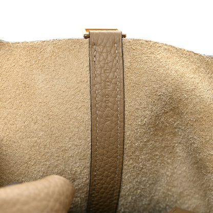 Beige leather strap detail with stitching and metal clasp attachment on side.