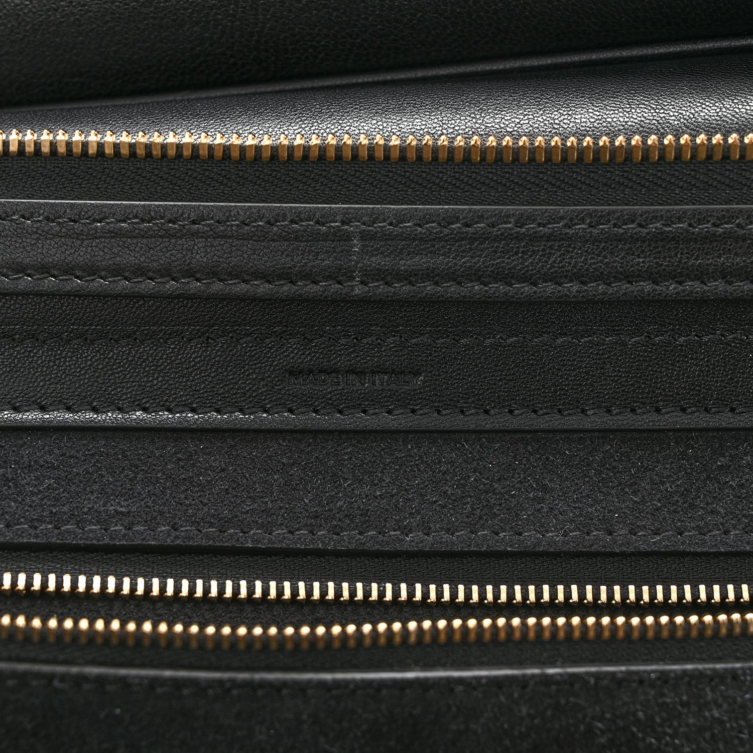 Celine black leather close-up with gold zipper track and stitched panels