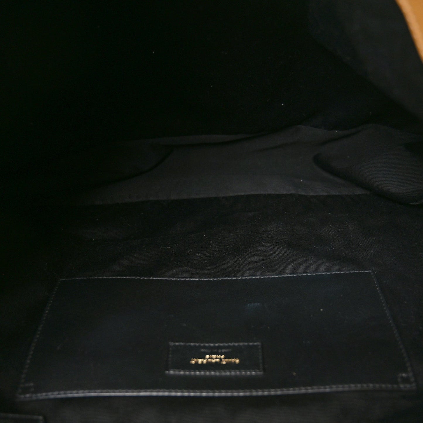 Lined interior pocket with logo label patch inside the bag