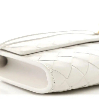 White nappa clutch side view with handle strap and open interior edge