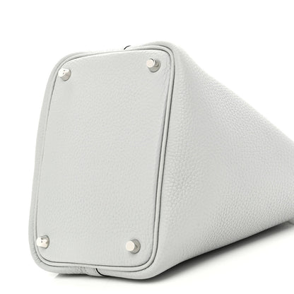Light blue pebbled leather bucket bag side with rounded panel and metal corner studs