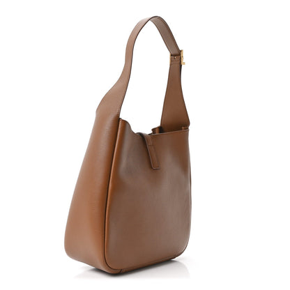 Tan leather hobo bag with short handles and slanted side profile