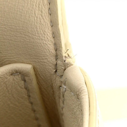 Close-up of nude calfskin side seam and stitching detail on the bag