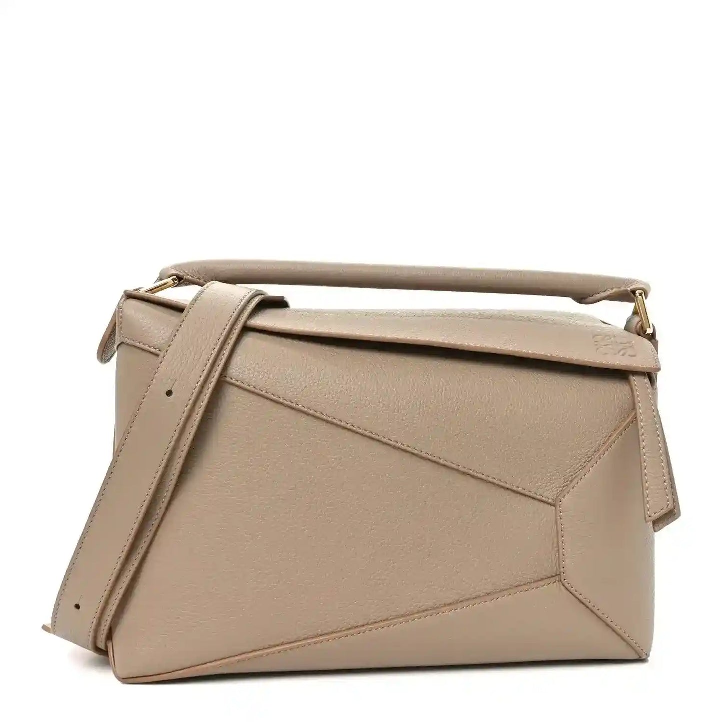 Sand leather satchel style bag with top handle, adjustable strap, and diagonal front seams.