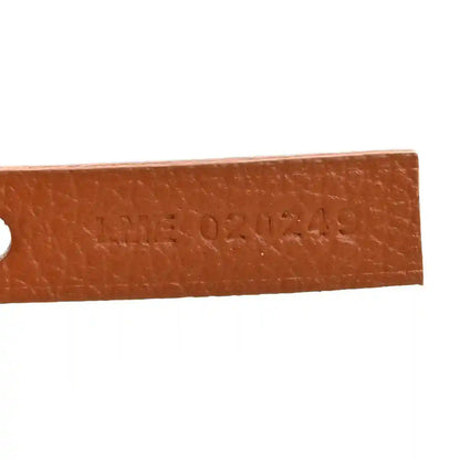 Goyard hobo bag close-up of embossed brand text on tan leather edge