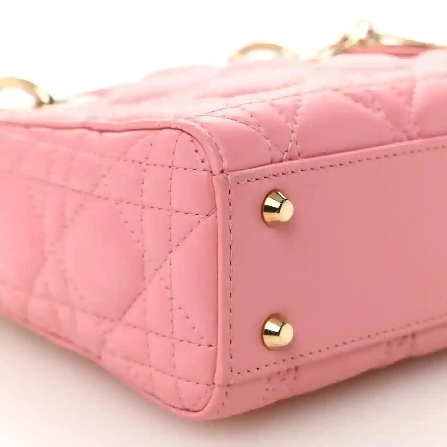 Light pink quilted mini handbag side with gold dome studs and leather trim