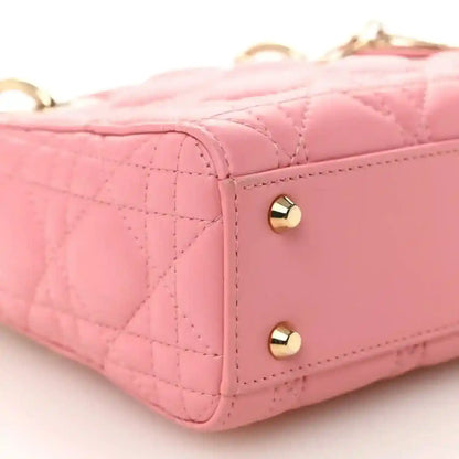 Light pink quilted mini handbag side with gold dome studs and leather trim