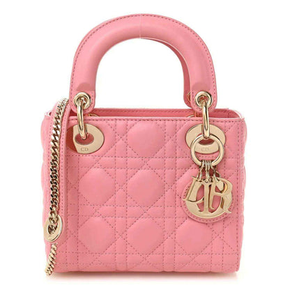 Light pink quilted mini handbag with top handles, chain strap, and CD charm