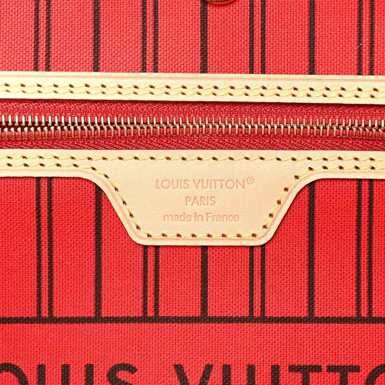 Louis Vuitton tote lining label on red striped fabric with tan stitching
