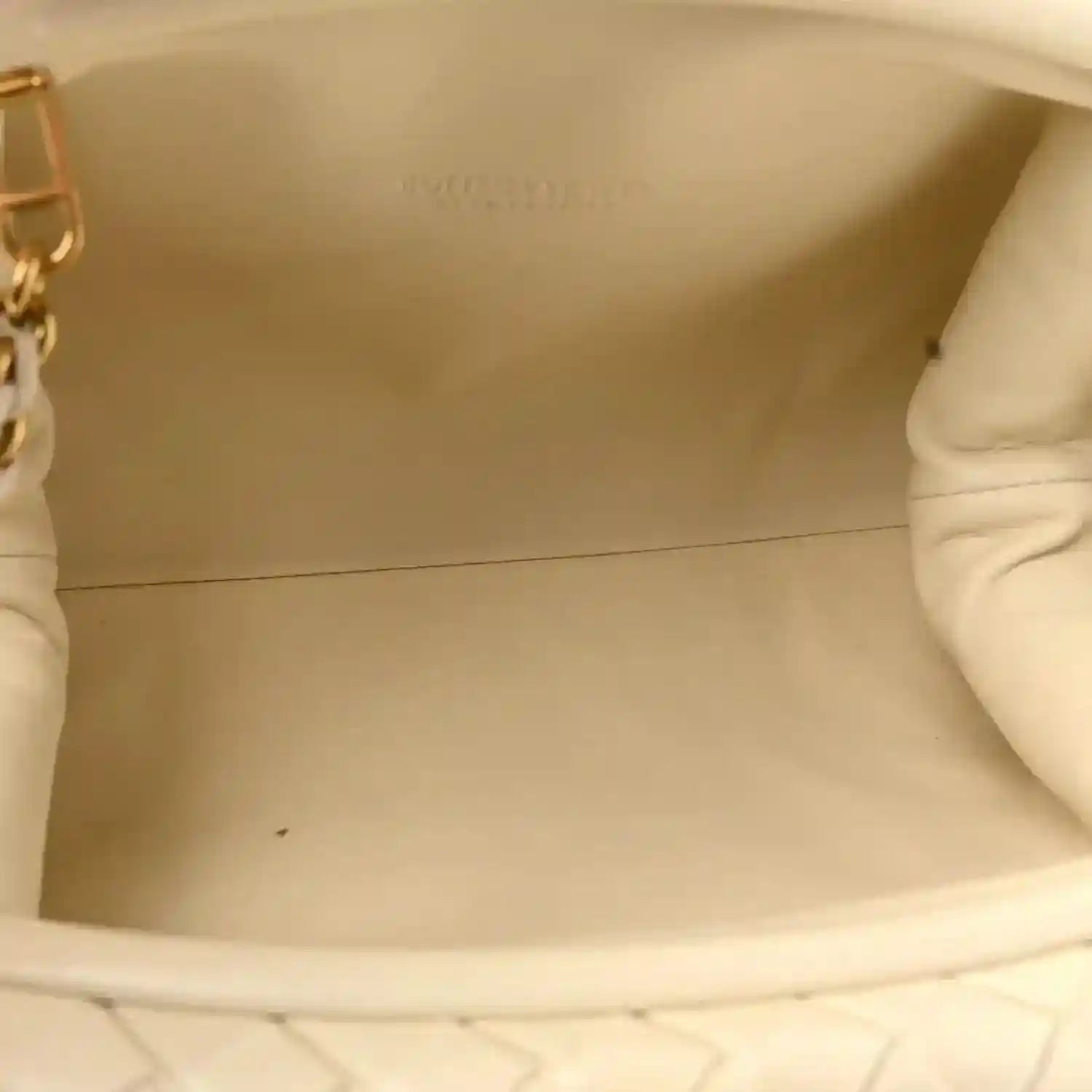 White leather clutch interior showing smooth lining and opening