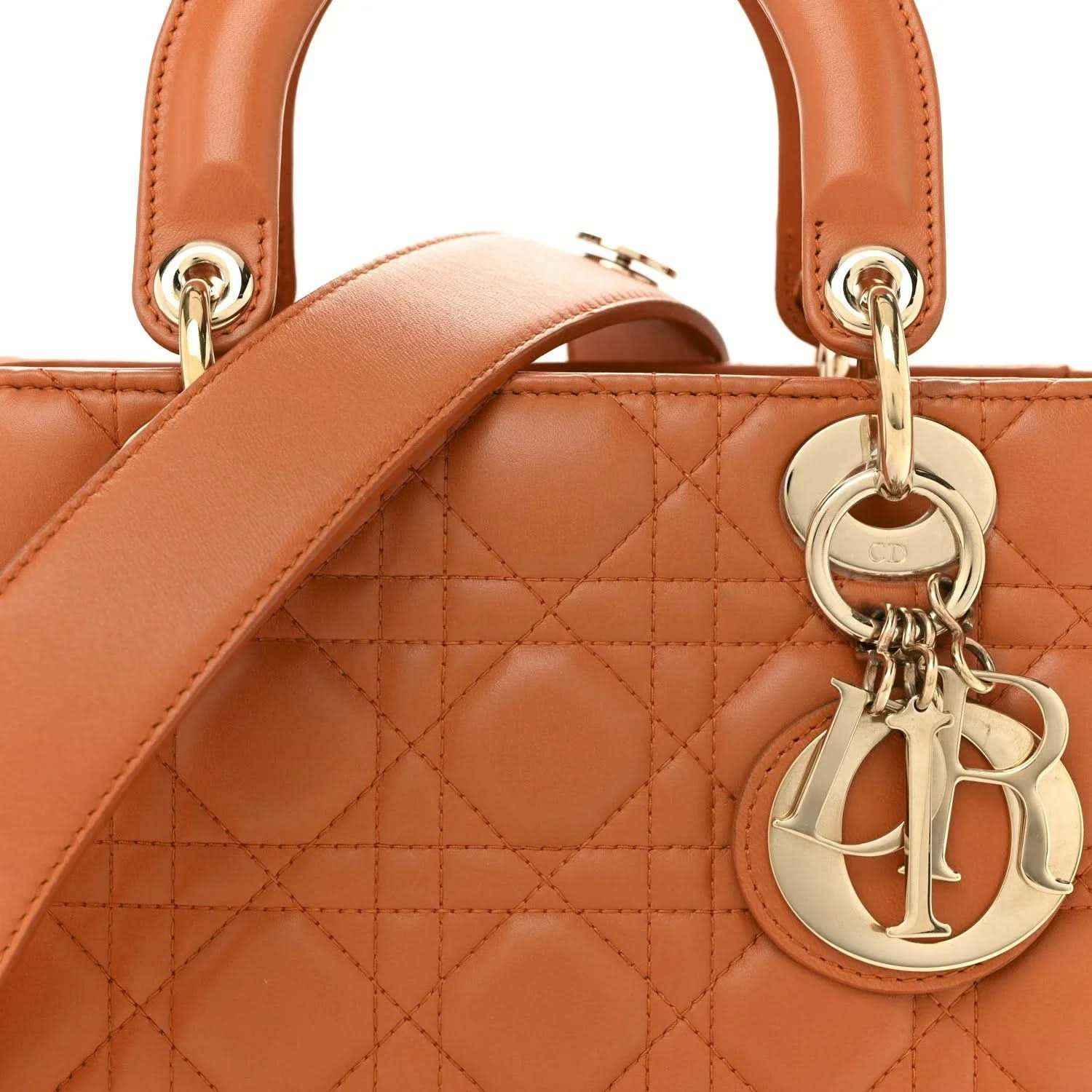Close-up of orange quilted Lady Dior tote with top handles and gold D charm