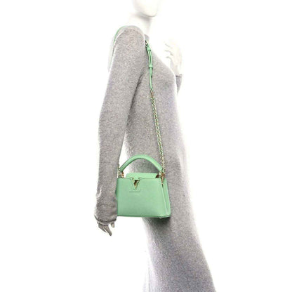 Green mini handbag with chain strap, side view