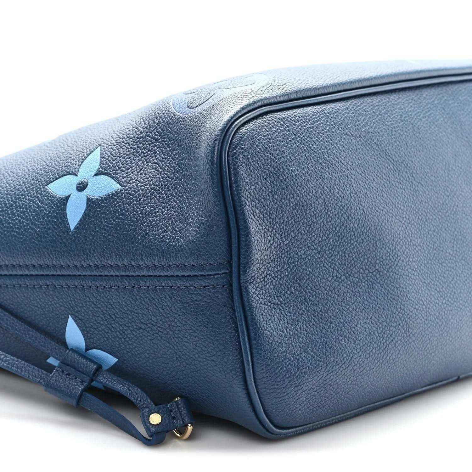 Blue monogram tote bag side view with structured corner and drawstring strap