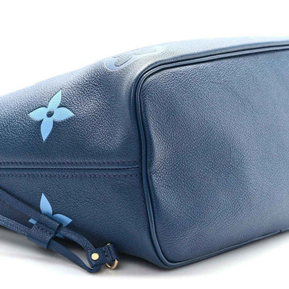 Blue monogram tote bag side view with structured corner and drawstring strap