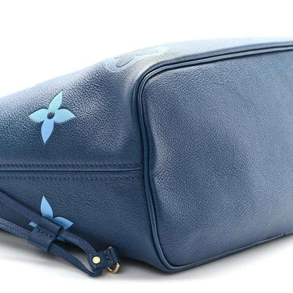 Blue monogram tote bag side view with structured corner and drawstring strap