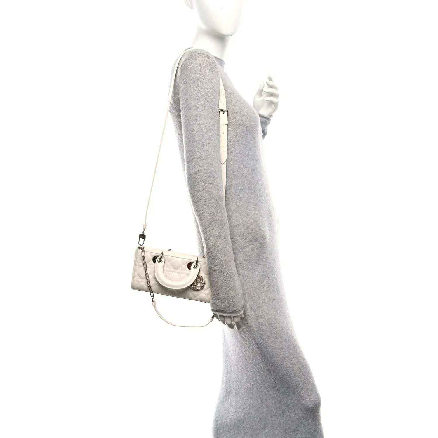 Small white quilted handbag on chain with short top handles and front charm
