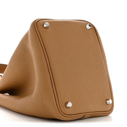 Tan leather bucket bag side view with grommet hardware on corners
