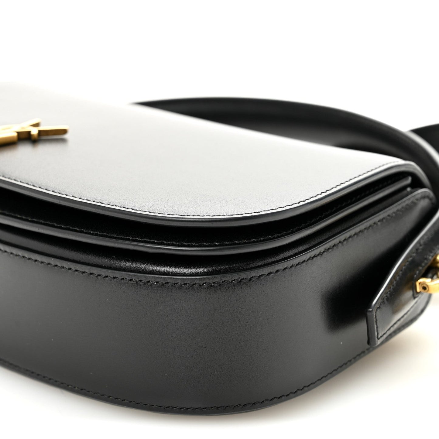 Bicolor crossbody bag detail with white top, black body, and strap attachment.