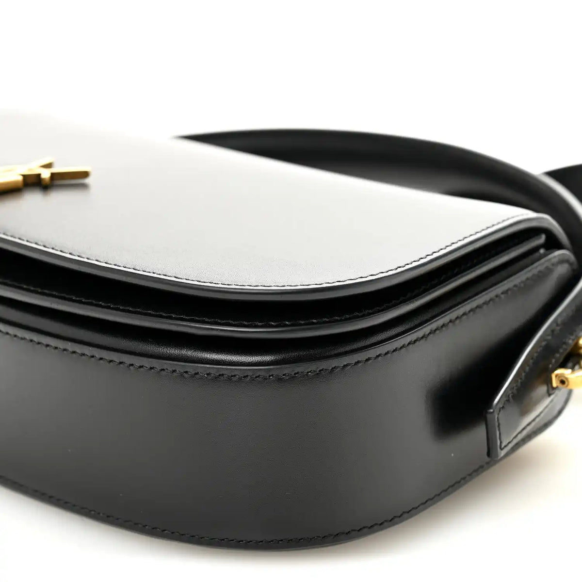 Bicolor crossbody bag detail with white top, black body, and strap attachment.