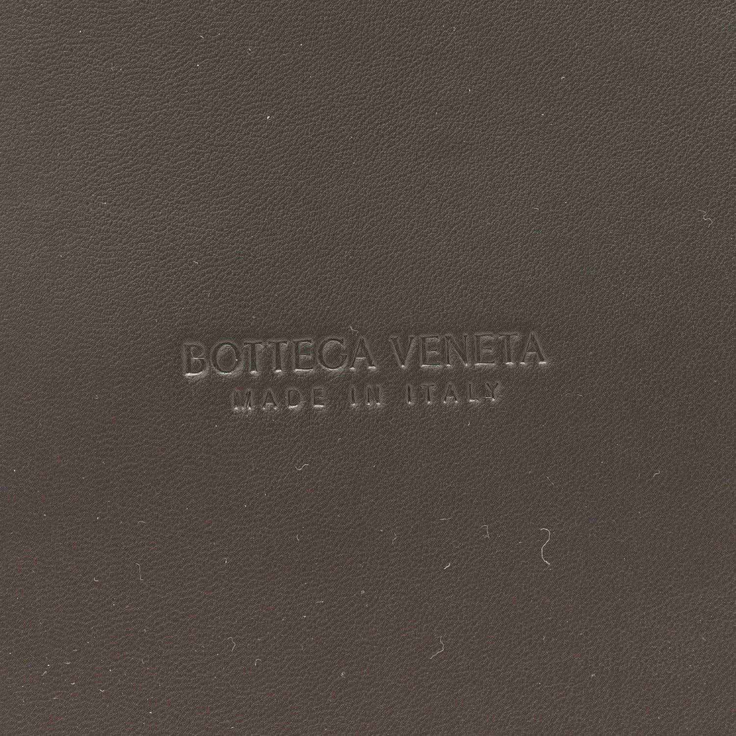 Bottega Veneta embossed on black leather surface