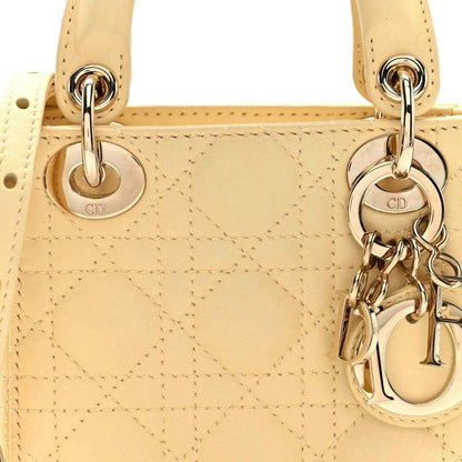 Soft yellow micro Lady Dior handbag front with cannage quilting and CD charm hardware