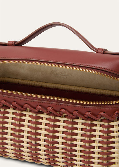 Wicker and calfskin pouch close-up of interior lining and gold zipper trim.