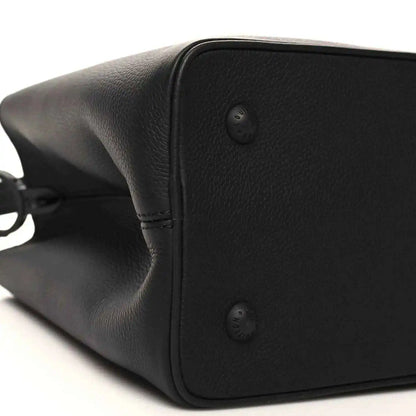 Black matte leather handbag side with corner studs and smooth curved edge
