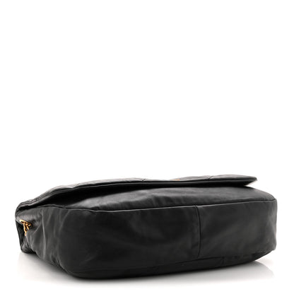 Black quilted lambskin shoulder bag side view with rolled top edge and gold hardware