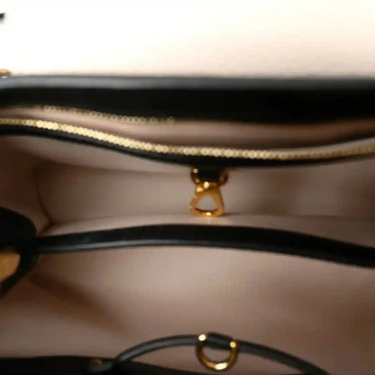 Leather handbag interior with gold zipper pull and chain ring