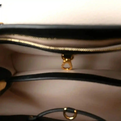 Leather handbag interior with gold zipper pull and chain ring