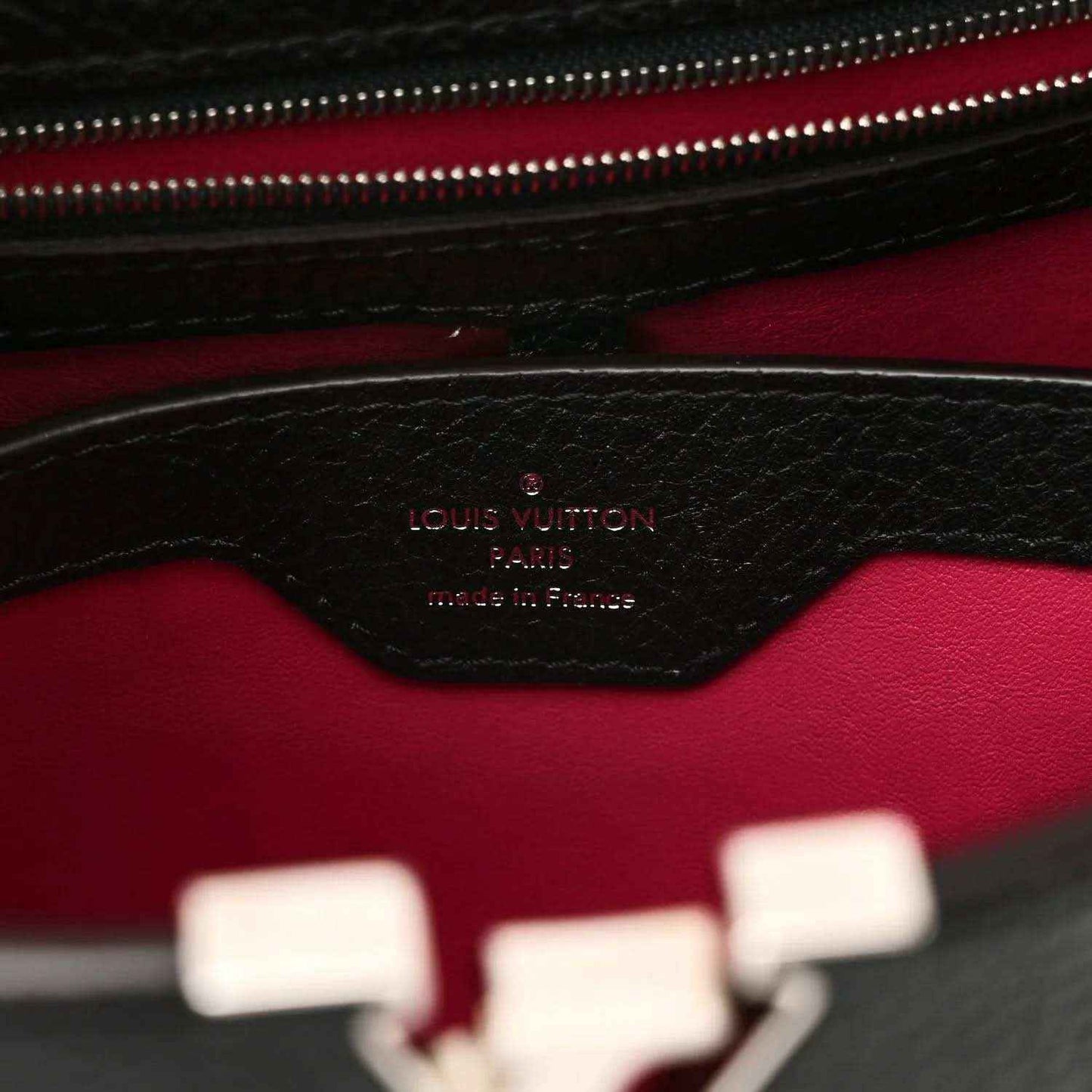 Black leather interior panel with fuchsia lining and embossed logo stamp
