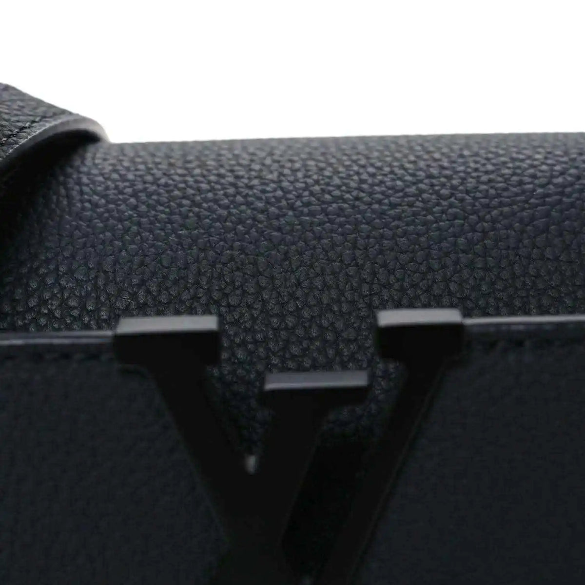 Black leather mini handbag front with raised LV emblem and textured grain.