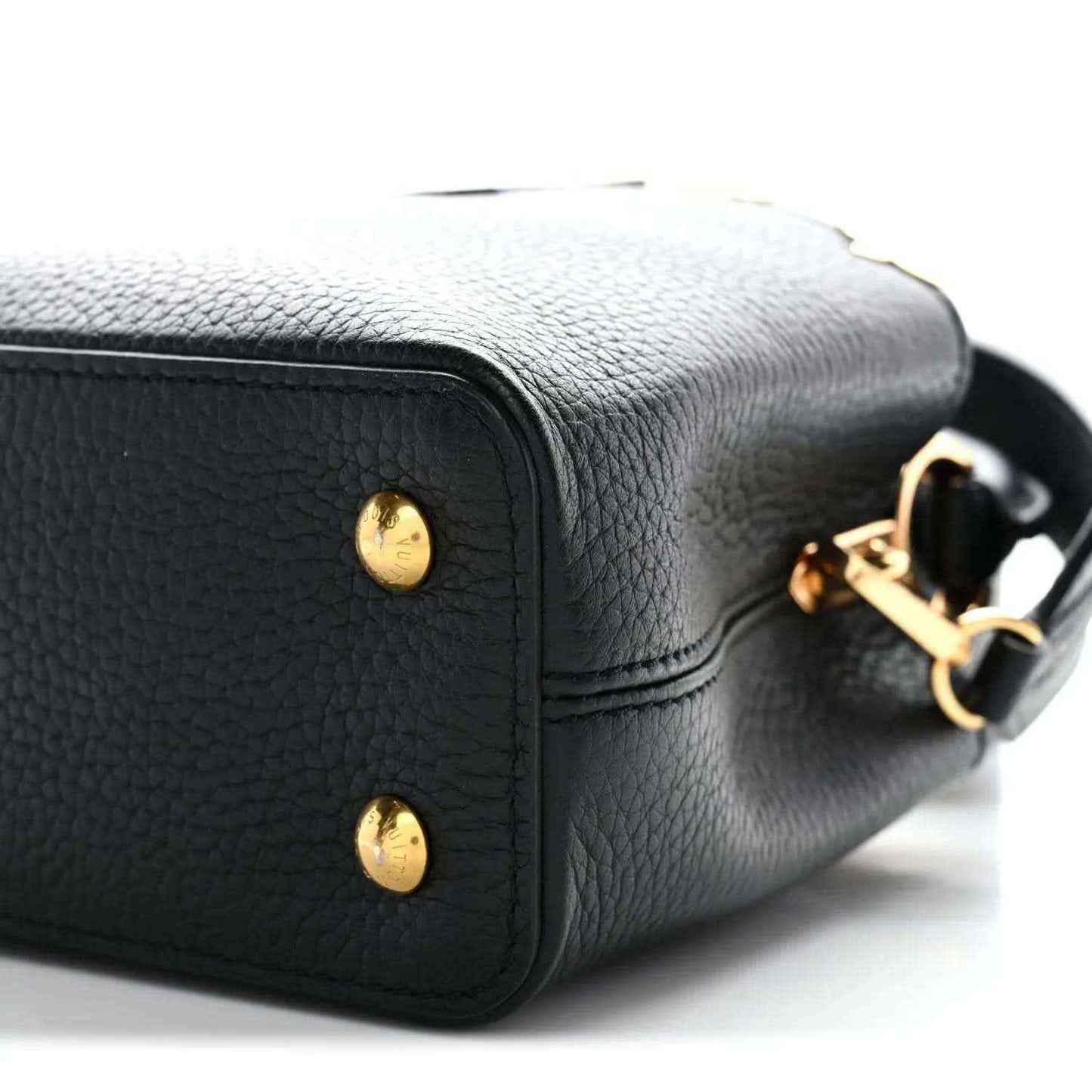 Black mini handbag corner close-up with gold stud buttons and logo hardware