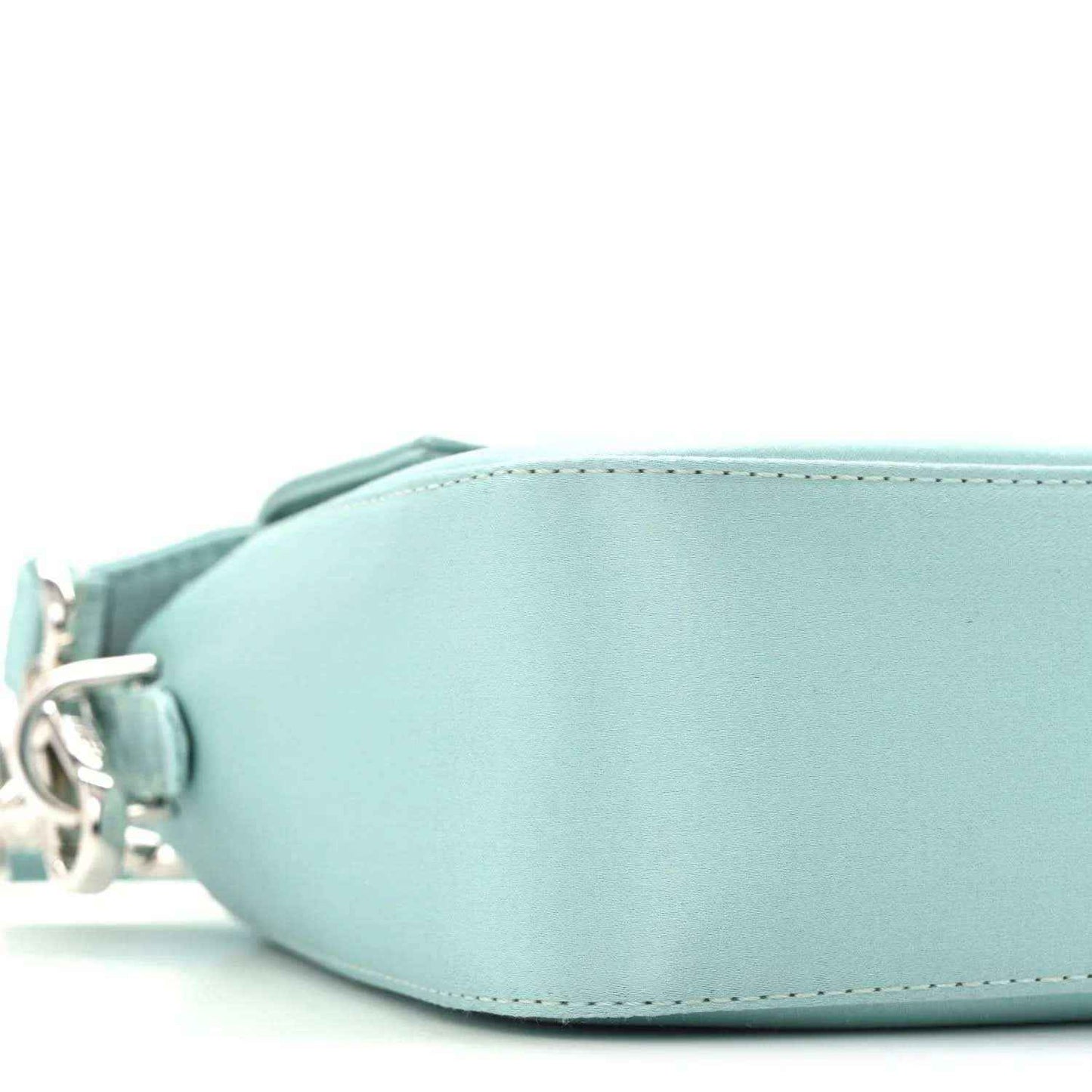 Blue satin baguette bag close-up of curved front and circular side hardware