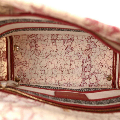 Canvas bag interior closeup with red-and-white stripe trim and gold rivets.