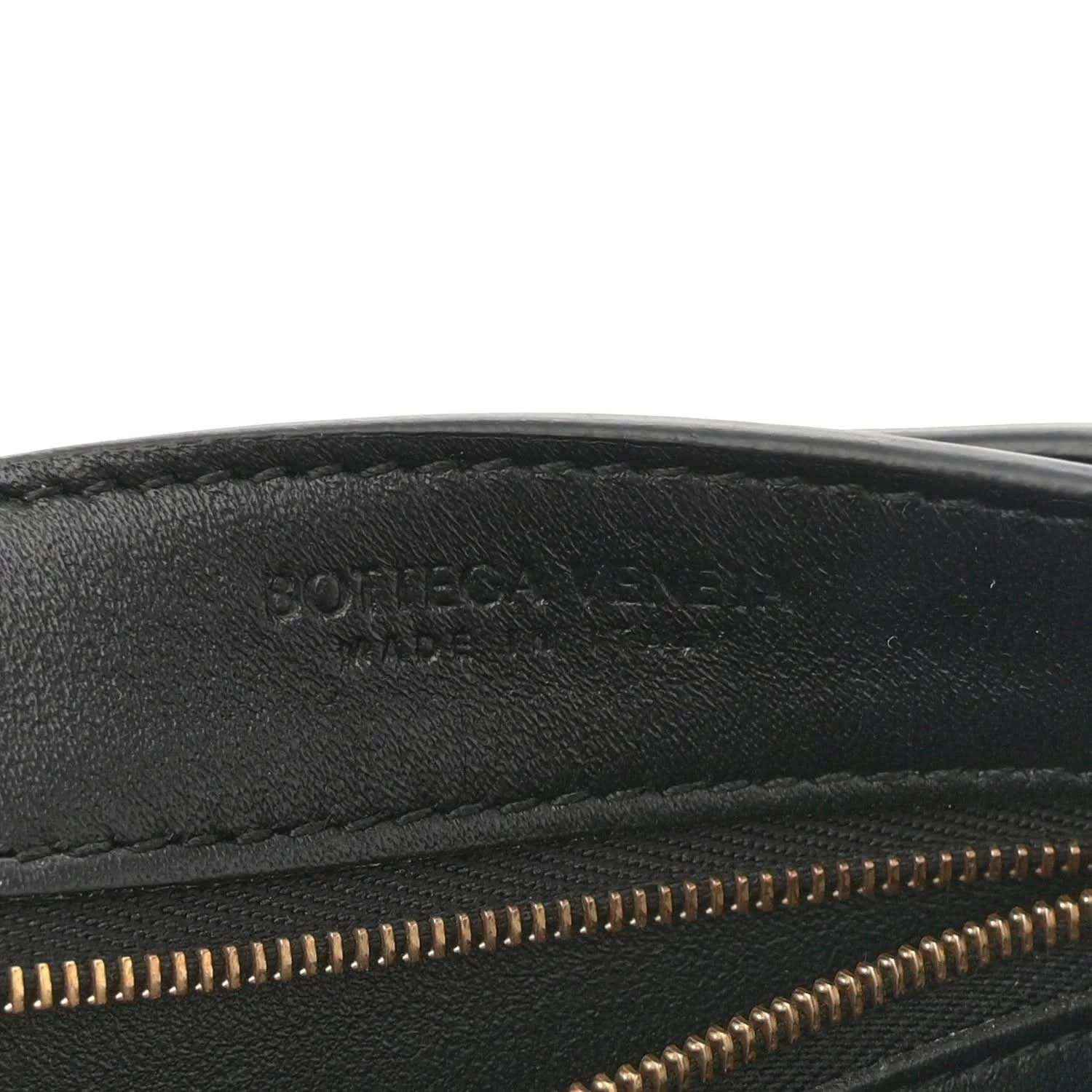 Black leather bag interior edge with gold zipper teeth and stitched seam