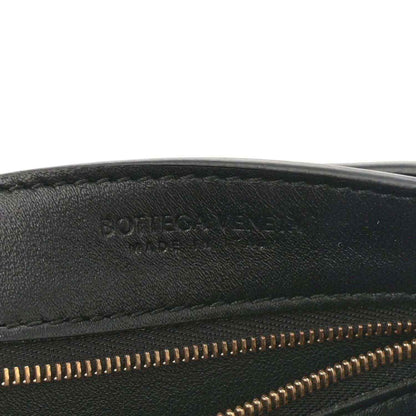 Black leather bag interior edge with gold zipper teeth and stitched seam